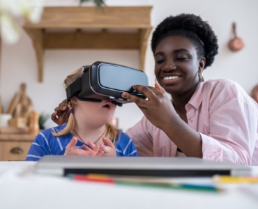 Teacher supervising child with VR headset